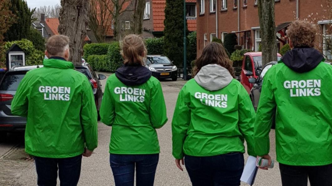 Foto van de achterkant van vier huis-aan-huis-lopers met GroenLinks-logo op de rug in Baarn.