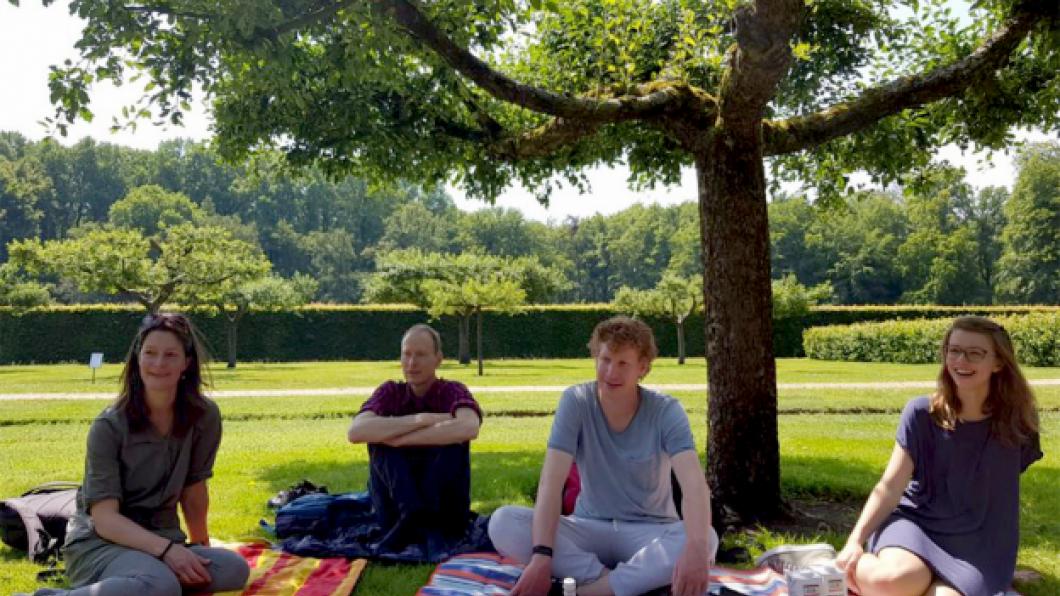 Foto van een aantal leden aan het picknicken in het gras.