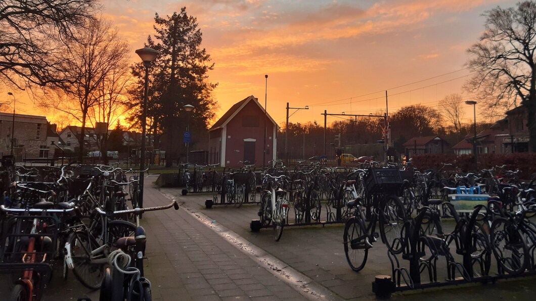 De fietsenstalling bij het station met een ondergaande zon erachter.