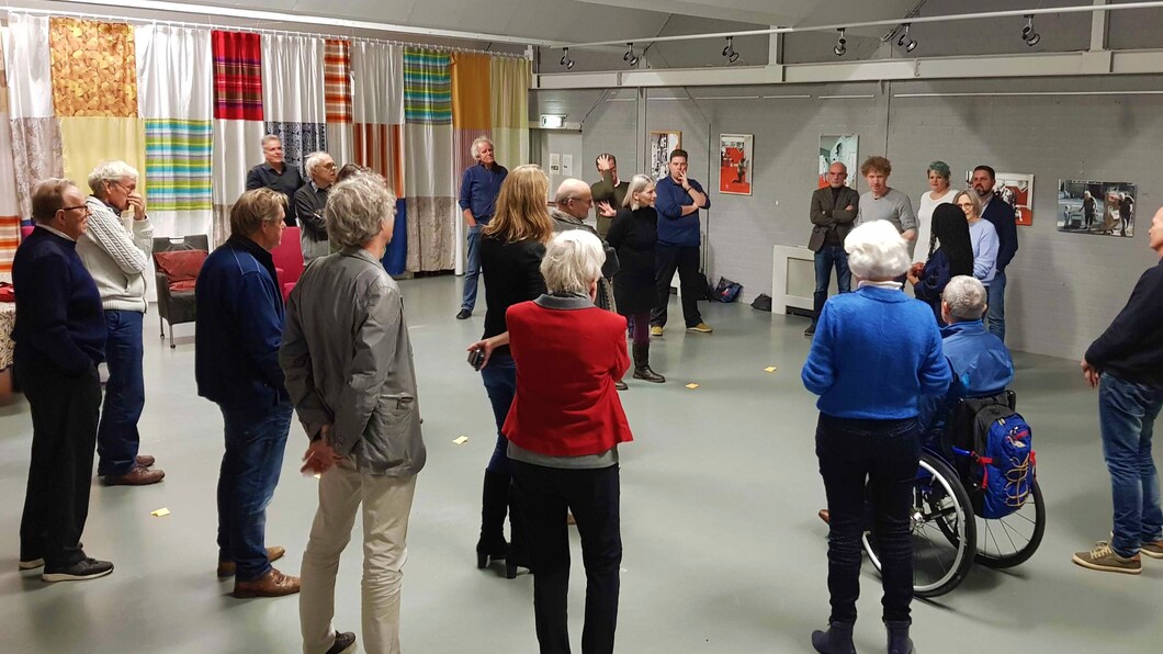 Zaal met een groep inwoners in een kring.