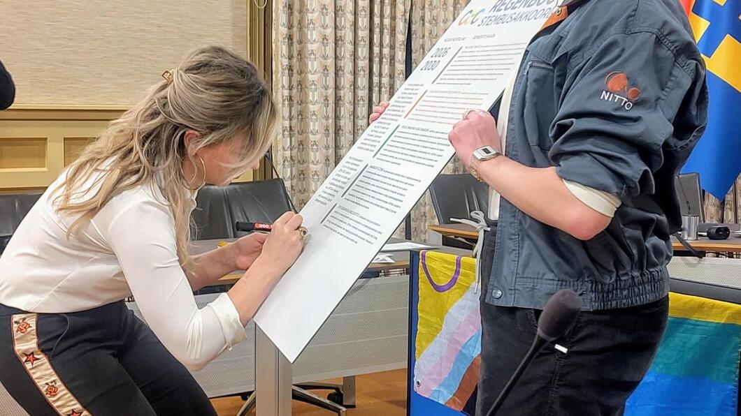 Lin Huisman tekent het Regenboogstembusakkoord.