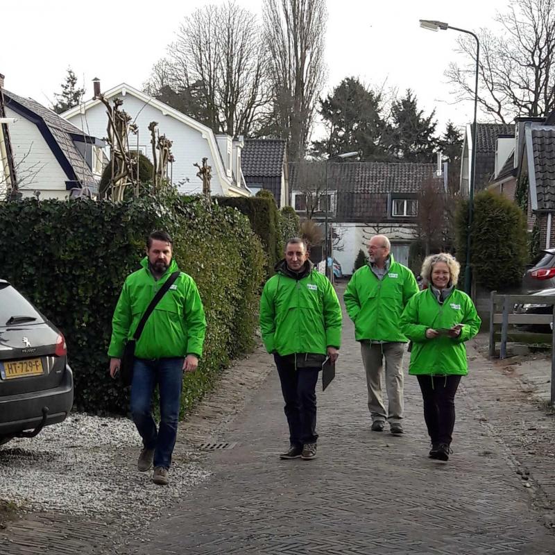 Vier GroenLinks-leden, inclusief Allal, lopen door een straat om campagne te voeren.