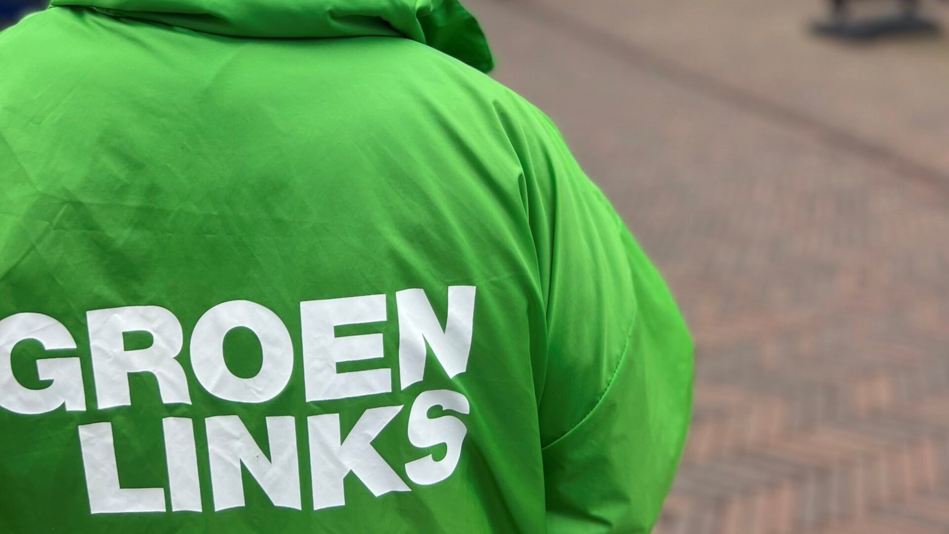 Foto van een vrijwilliger in een GroenLinks-jasje, van de achterkant gezien. 